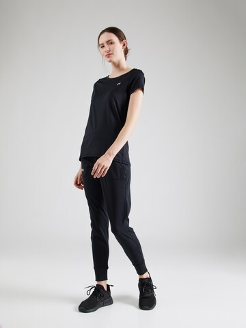 Tapered Pantaloni sportivi 'Motion' di UNDER ARMOUR in nero